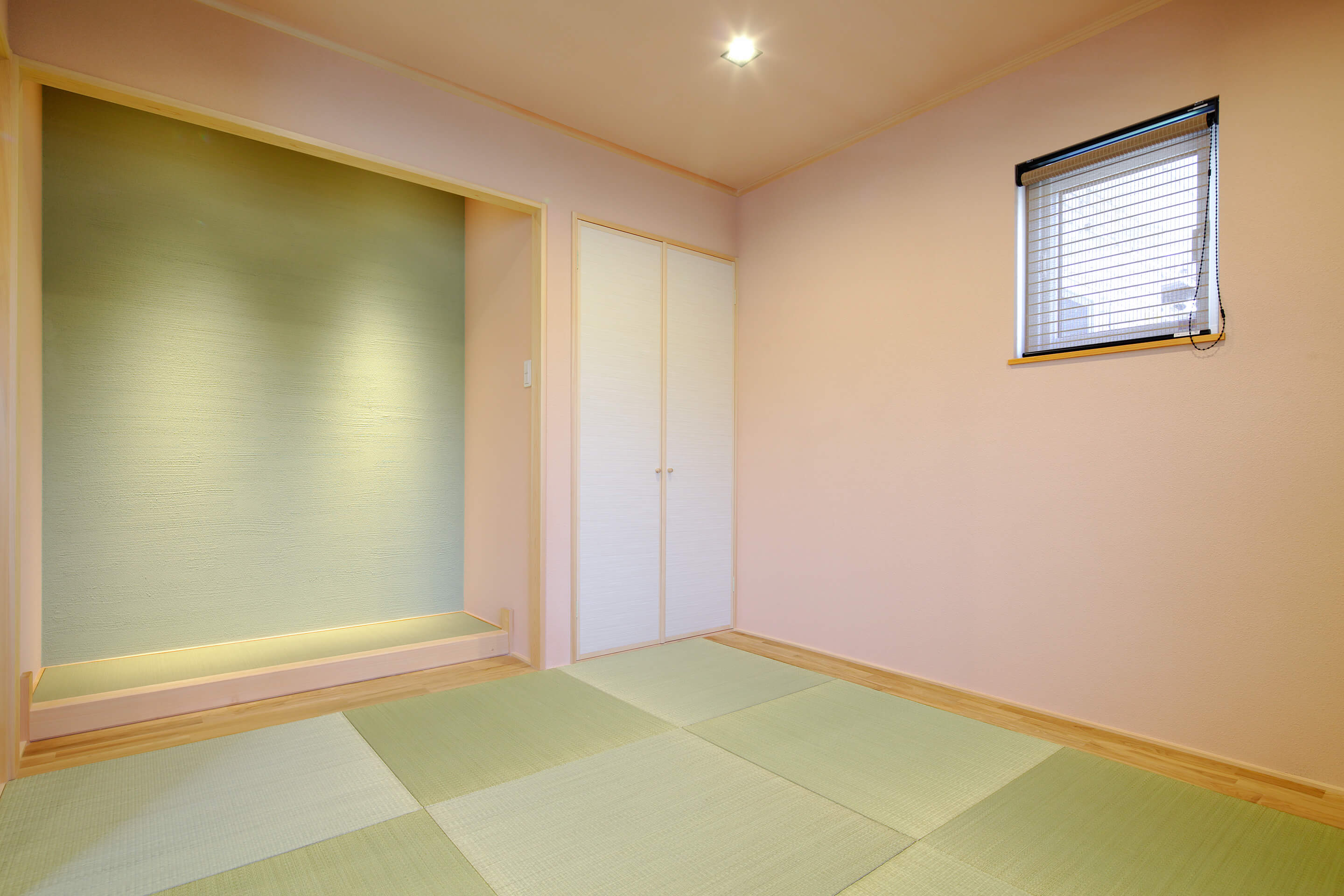 素材から考えた健康を育むレンガ積みの家のベビーピンクとパステルグリーンの塗り壁を取り入れた和室の写真