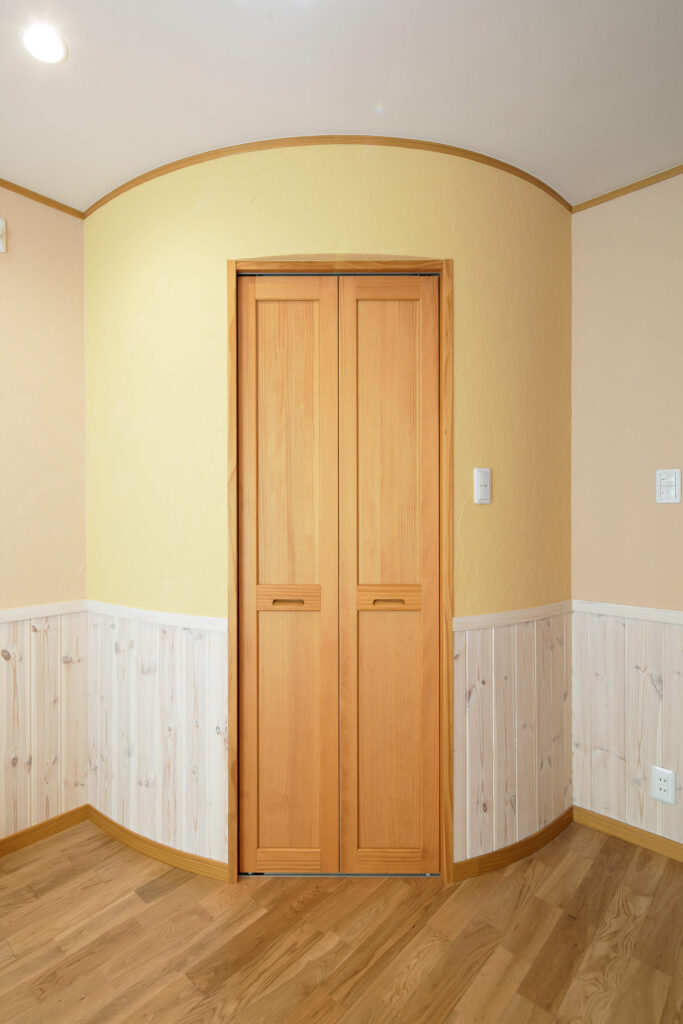 素材から考えた健康を育むレンガ積みの家のやわらかな曲線の円形クローゼットがある洋室の写真