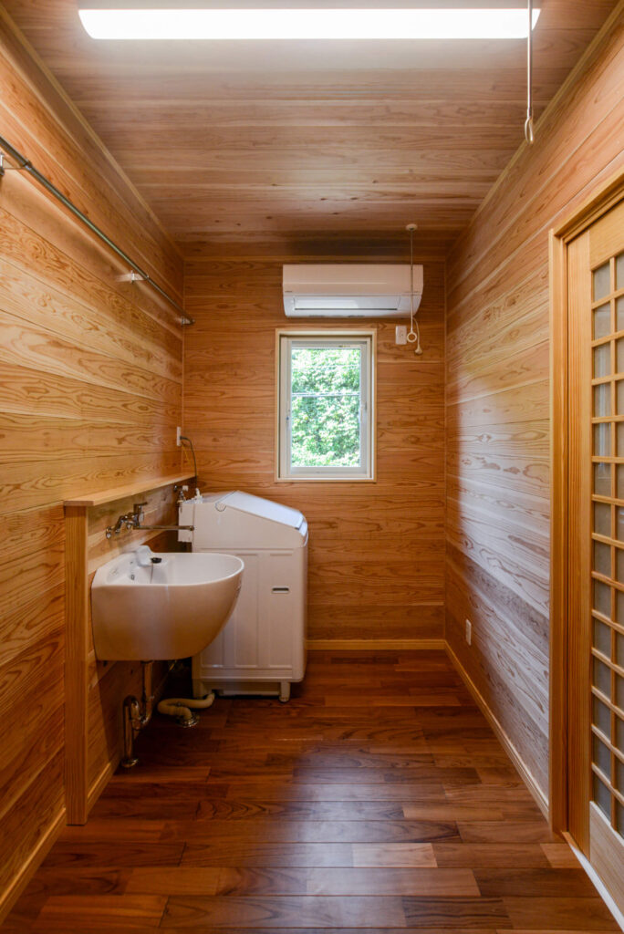 建築医学が息づく心身を整えるレンガ積みの家の快適に家事ができるランドリールームの写真