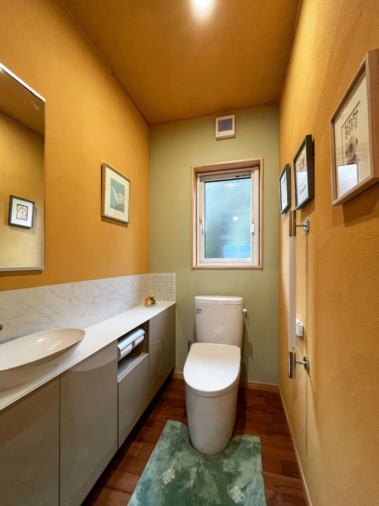 建築医学が息づく心身を整えるレンガ積みの家の緑の色彩計画を取り入れた気持ちが整うトイレの写真