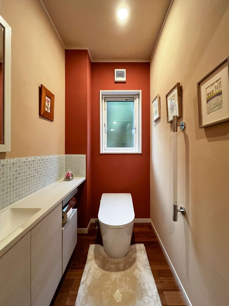 建築医学が息づく心身を整えるレンガ積みの家の深い赤の色彩計画を取り入れた健康的なトイレの写真