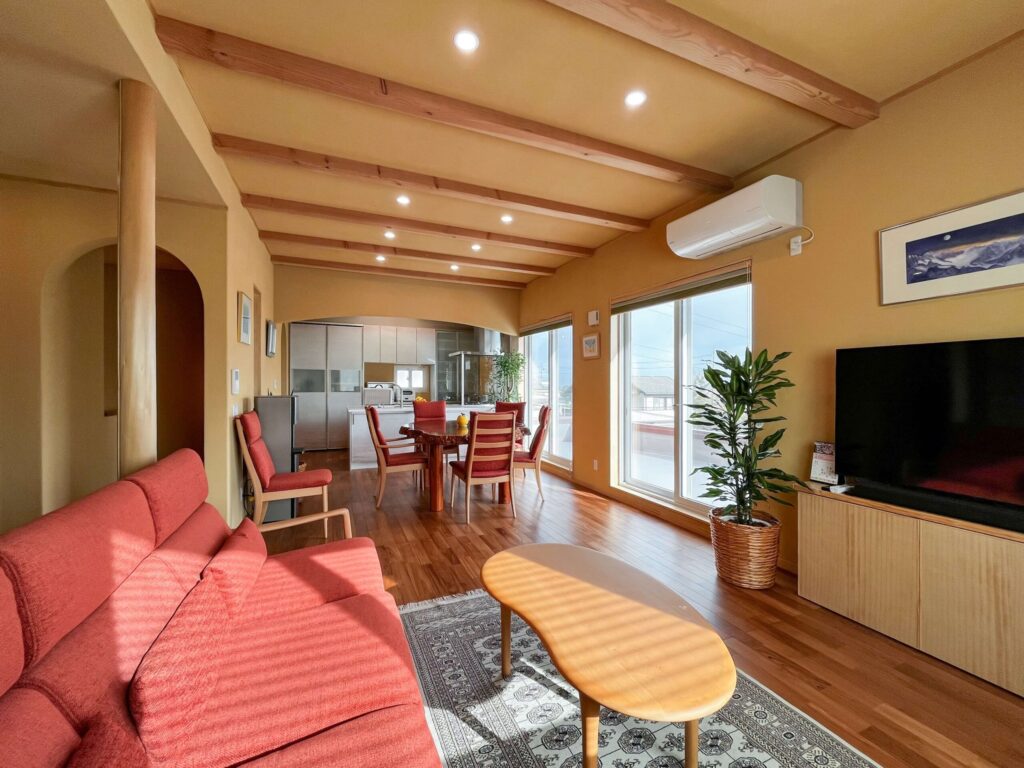 建築医学が息づく心身を整えるレンガ積みの家の光に満ちた明るいリビングの写真