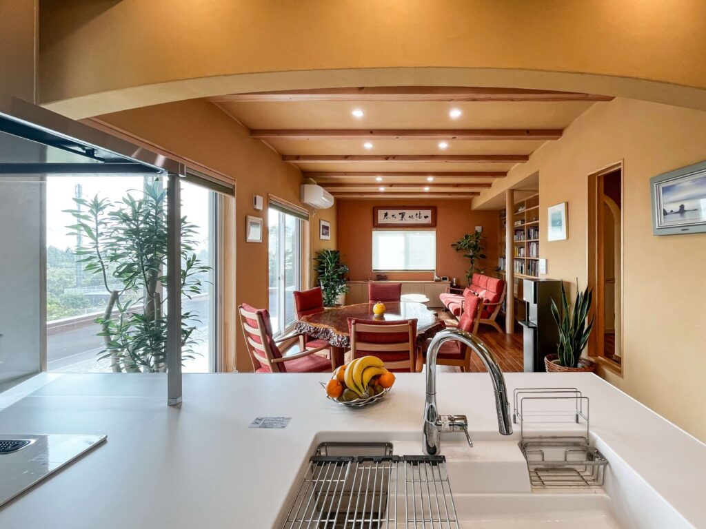 建築医学が息づく心身を整えるレンガ積みの家の曲線を取り入れた下がり壁があるキッチンの写真