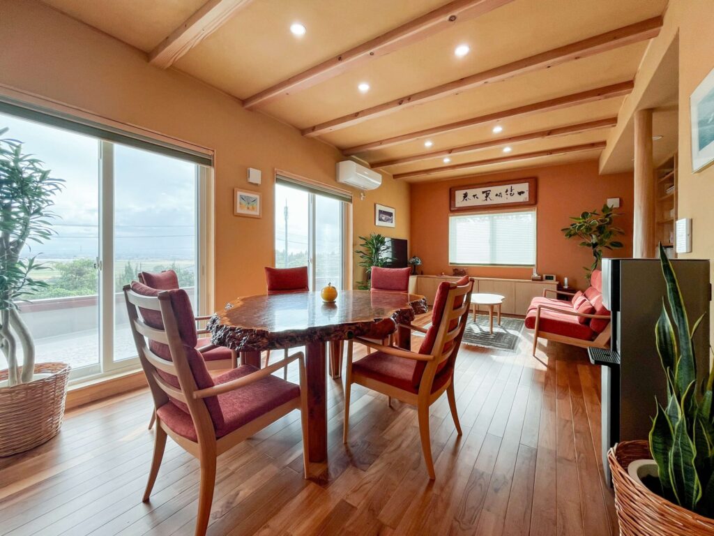 建築医学が息づく心身を整えるレンガ積みの家の観葉植物と一枚板のダイニングテーブルがあるリビングの写真