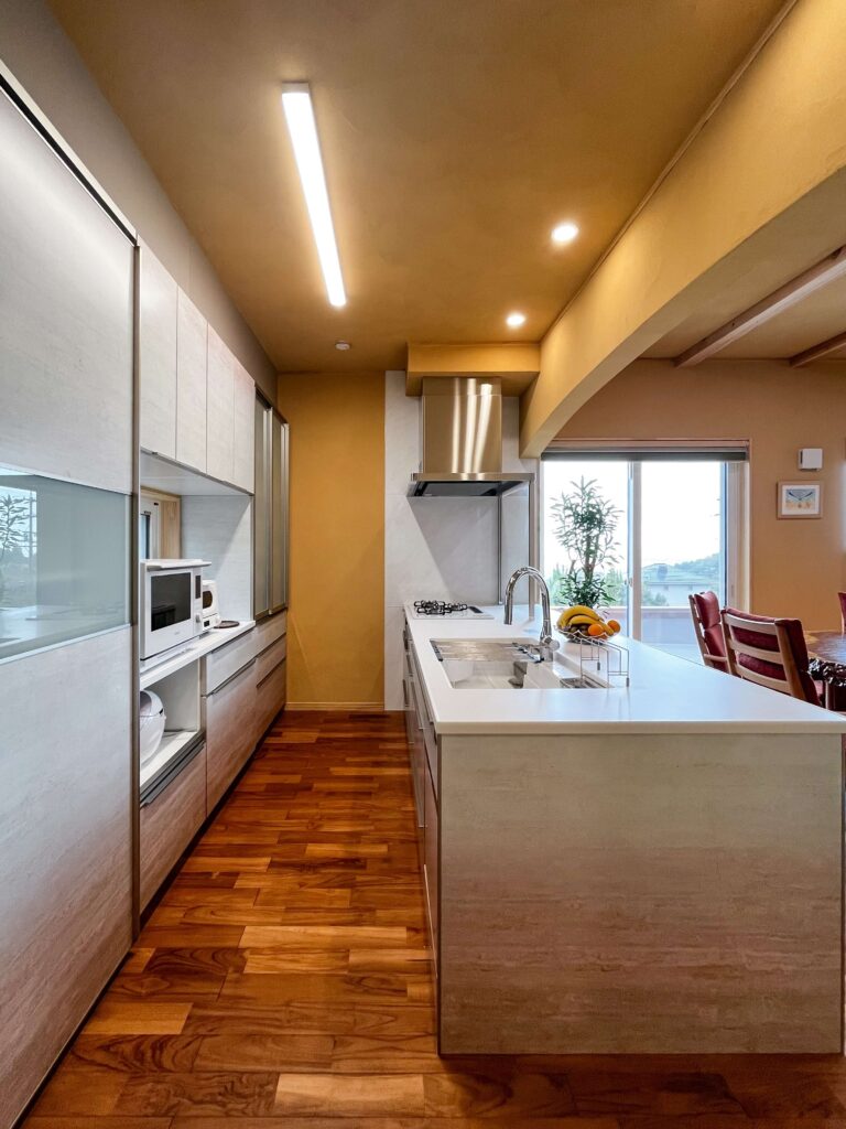 建築医学が息づく心身を整えるレンガ積みの家の広い作業スペースと充実した収納を備えたキッチンの写真