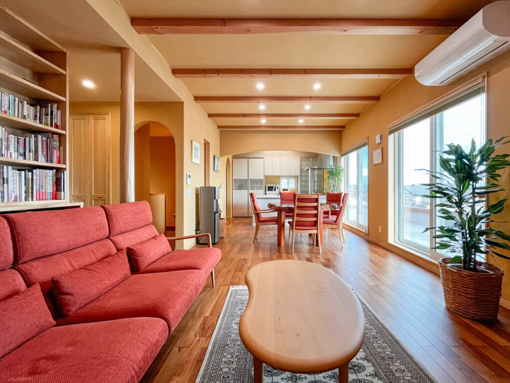 建築医学が息づく心身を整えるレンガ積みの家の塗り壁を採用した自然光が広がるリビングの写真