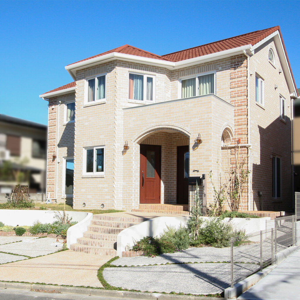 お医者さまのご主人が選んだ、健康に暮らすレンガ積みの青い空に映える優しい色合いのレンガとオレンジ色の屋根