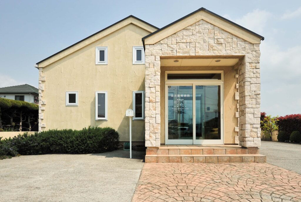 強い海風の吹く街で砂埃も結露もない快適に暮らす家の石調外壁タイルが映える玄関