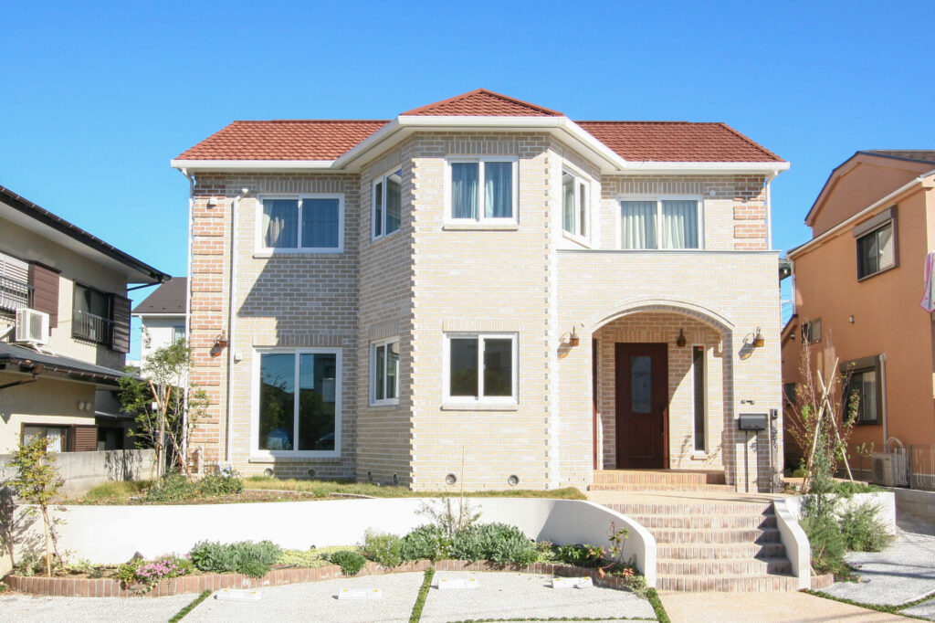 お医者さまのご主人が選んだ、健康に暮らすレンガ積みの家中央の多角形の塔、その横にアーチ型の玄関