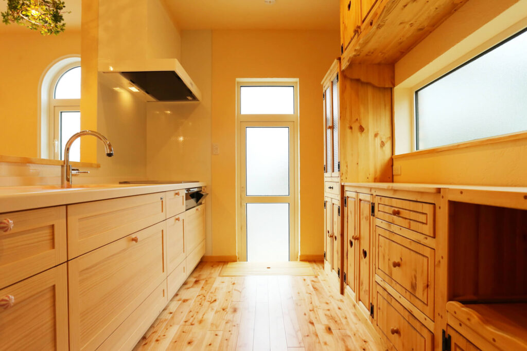 中世のお城のような優美なレンガ積みの家の木質系の素材を多用したキッチン内部