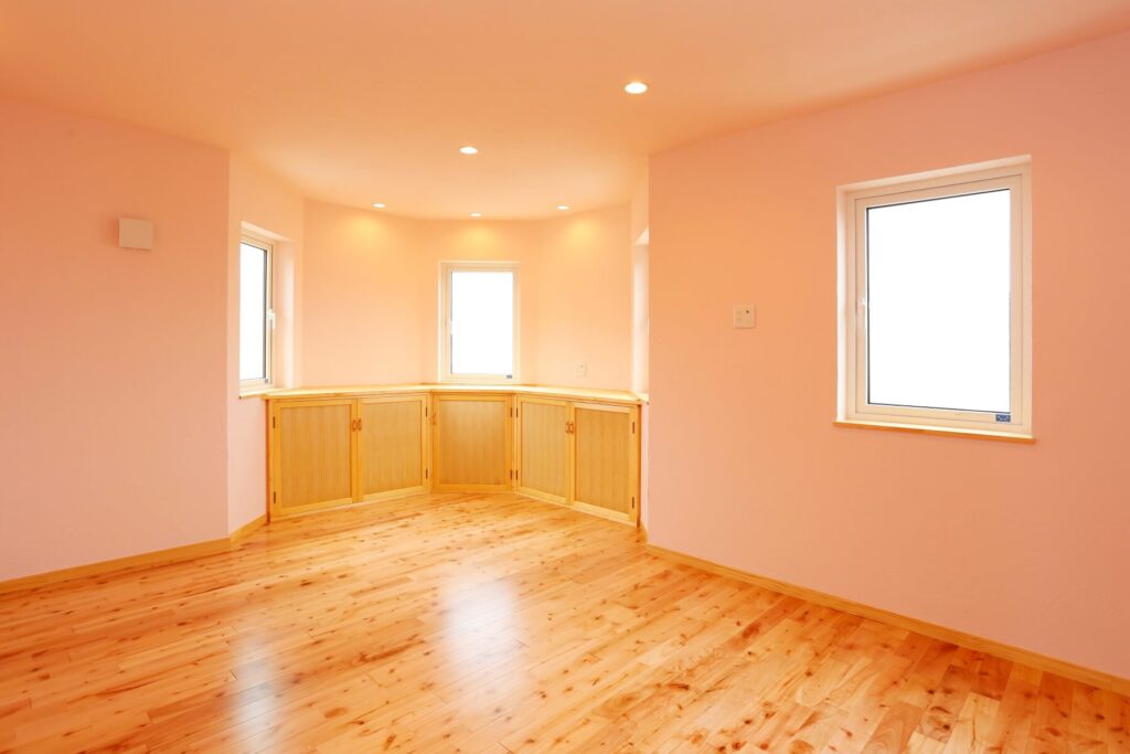 中世のお城のような優美なレンガ積みの家の光がたっぷり入るピンクの壁の2階洋室