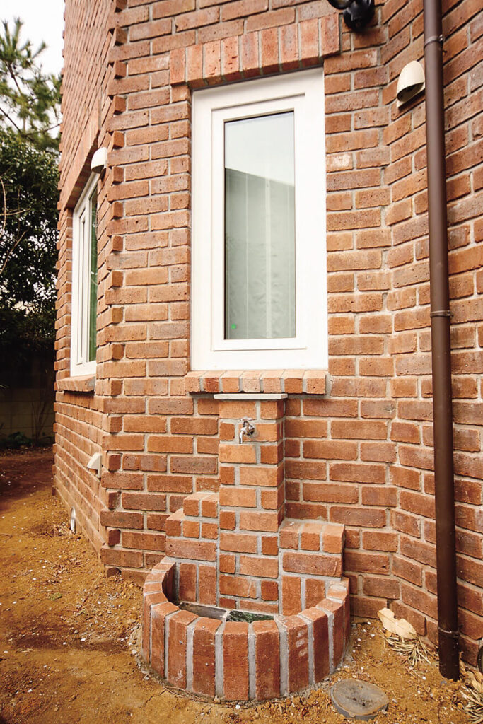 構造と性能で快適さと楽しい暮らしを追求したガレージハウスのレンガの立水栓