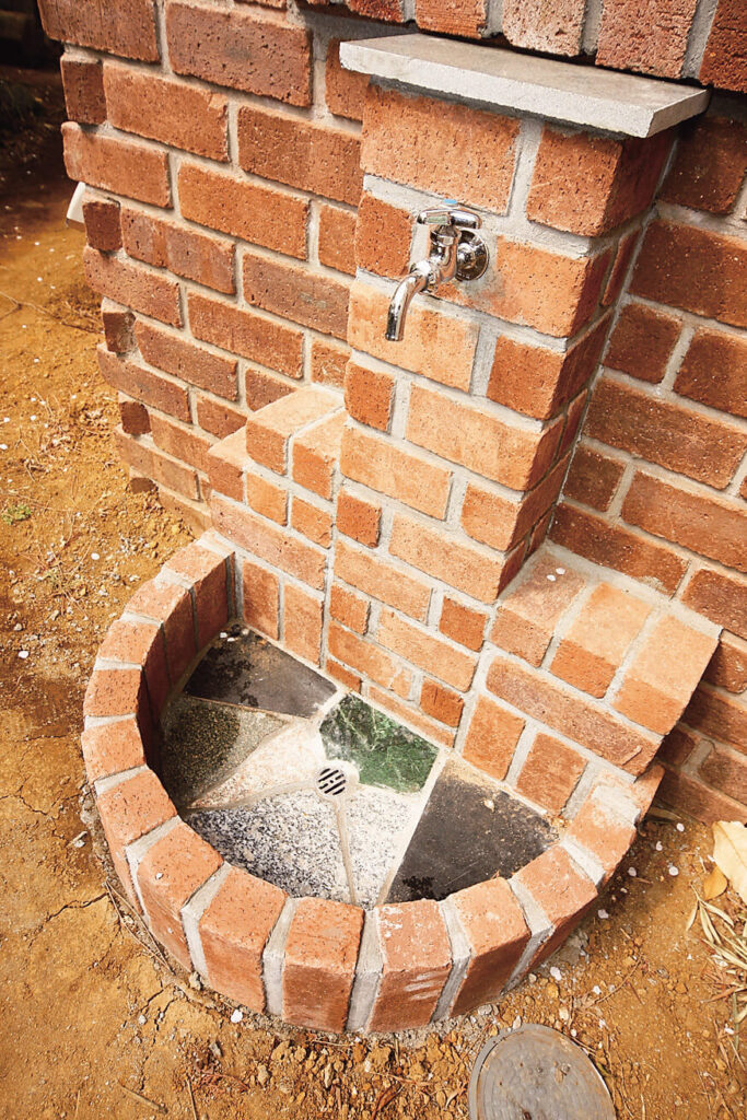 構造と性能で快適さと楽しい暮らしを追求したガレージハウスの立水栓の石材を利用した水受け